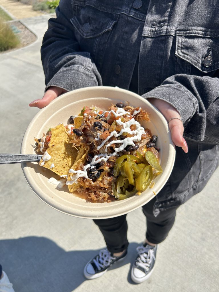 nacho bowl, including chips, cheese, beans, sour cream, and jalapenos